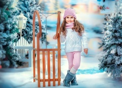 Dziewczynka z sankami na śniegu