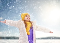 Dziewczynka zachwycona padającym śniegiem