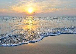 Fale na morskiej plaży w słonecznym blasku