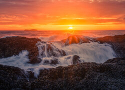 Fale na skałach w blasku zachodzącego słońca nad morzem