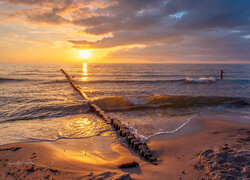 Falochrony w blasku zachodzącego słońca nad morzem