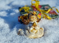 Figurka aniołka i prezent na śniegu