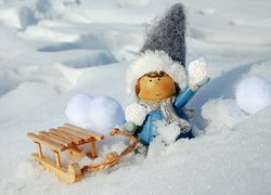 Figurka z sankami w śniegu