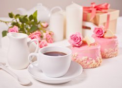 Filiżanka herbaty obok ciastek z różyczkami