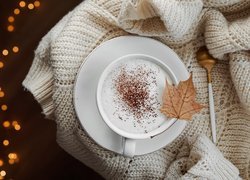Filiżanka kawy cappuccino na swetrze