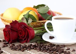 Filiżanka kawy obok czerwonych róż