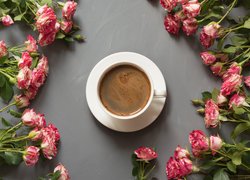 Filiżanka kawy pośród róż