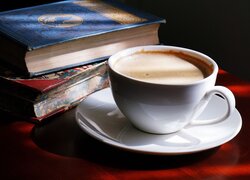 Filiżanka z kawą obok książek