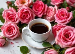 Filiżanka z kawą obok różowych róż