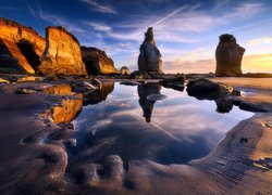 Nowa Zelandia, Region Taranaki, Tongaporutu, Zachód słońca, Plaża, Skały