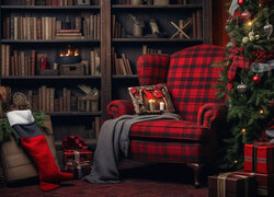 Fotel z poduszką i kocem obok choinki na tle regału z książkami