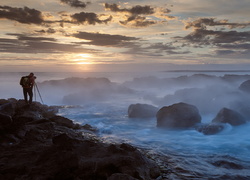 Fotograf nad wzburzonym morzem o świcie