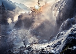 Górski wodospad w zimowej porannej mgle