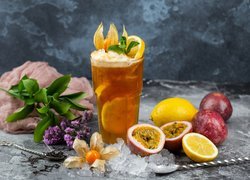 Granaty i cytryna obok napoju owocowego