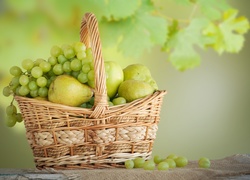 Gruszki i kiście winogron w koszyku