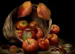 Jabłka i jesienne liście w koszyku