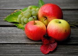 Jabłka i winogrona na deskach