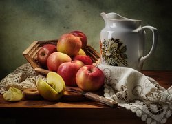 Jabłka w koszyku obok porcelanowego dzbanka