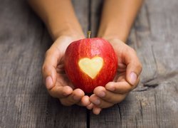 Jabłko z wyciętym sercem w dłoniach