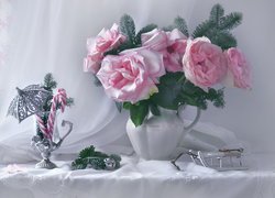 Jasnoróżowe róże w wazonie obok parasolki i lizaków w szklance