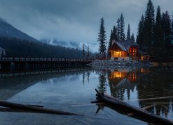 Jezioro Emerald Lake i oświetlony dom na tle gór o zmierzchu