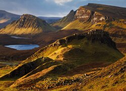 Jezioro i rozświetlone wzgórza Quiraing na wyspie Skye w Szkocji