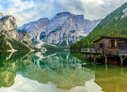 Jezioro Pragser Wildsee z drewnianą chatą na palach we włoskich Dolomitach
