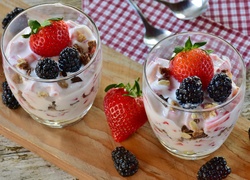 Jogurtowe desery z musli w szklankach ozdobione jeżynami i truskawkami