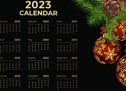 Kalendarz na 2023 rok obok bombek i szyszek na gałązkach