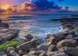 Kamienie na brzegu i zachód słońca nad morzem