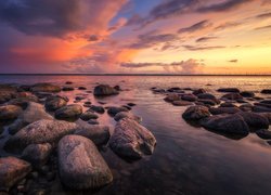 Kamienie na brzegu morza w blasku zachodzącego słońca