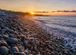 Kamienie na brzegu morza w promieniach słońca