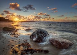 Kamienie na plaży w promieniach zachodzącego słońca