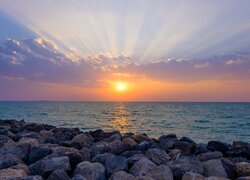 Kamienie na wybrzeżu morza w blasku zachodzącego słońca