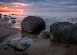 Kamienisty brzeg morza w promieniach zachodzącego słońca