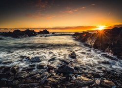 Kamienisty brzeg plaży w szkockiej wsi Sandend o wschodzie słońca