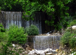 Kamienisty wodospad wśród drzew i krzewów