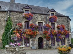 Kamienny dom i studnia w Rochefort en Terre ozdobione kwiatami