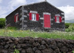 Kamienny dom z czerwonymi okiennicami