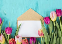 Kartka na kopercie pośród tulipanów