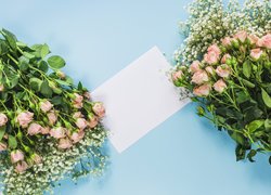 Kartka pomiędzy dwoma bukietami róż z gipsówką