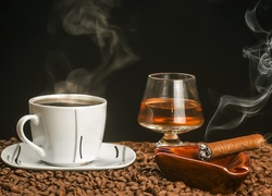 Kawa w filiżance i koniak w kieliszku obok cygara leżącego na popielniczce