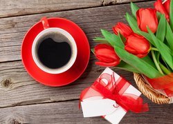 Kawa w filiżance obok prezentu i bukietu tulipanów