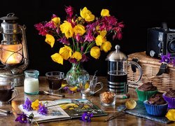 Kawiarka obok bukietu kwiatów i lampy naftowej