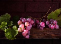 Kiść różowych winogron na drewnie