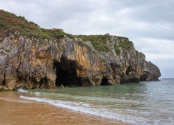 Klif z jaskinią nad brzegiem morza