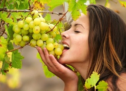 Kobieta delektuje się smakiem winogron