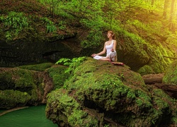 Kobieta medytująca na skale