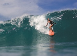 Kobieta na desce windsurfingowej pokonuje fale