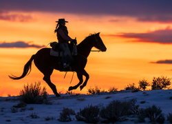 Kobieta na koniu i zachód słońca w tle